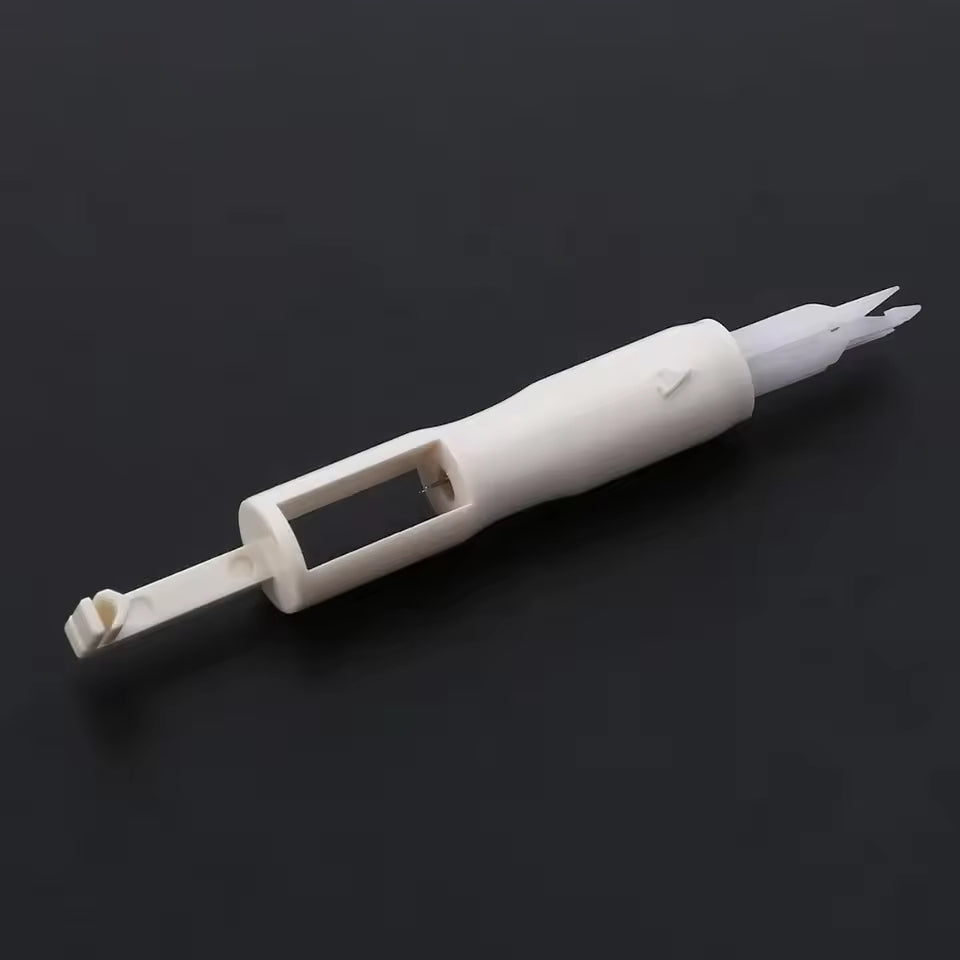 A white plastic IC extraction tool with a handle and tapered ends sits on a dark background, similar to the precision found in Sewing Machine Needles for Quilting (20pcs - 70/10 90/14 100/16).