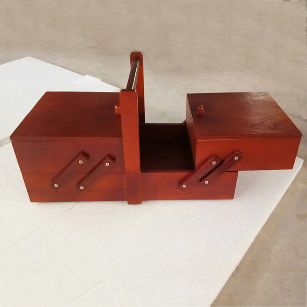 The Wooden Sewing Box with Handle is a handcrafted pinewood organizer, featuring multiple compartments, a red-brown finish, and an elegant design for sewing supplies on any light surface.