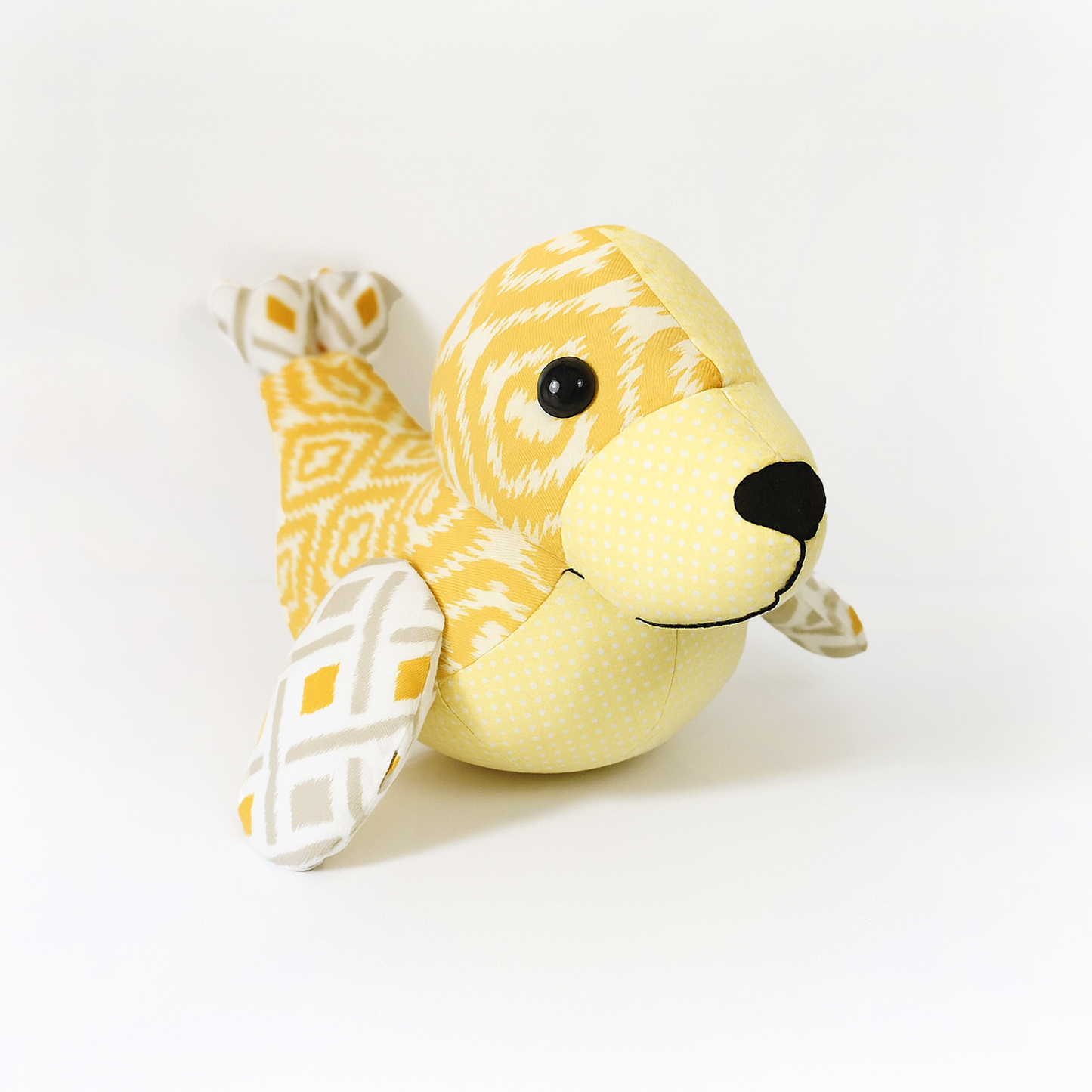 Tidey the Seal Quilt Pattern: Downloadable PDF for creating a yellow and white patterned plush seal with black nose and eyes.