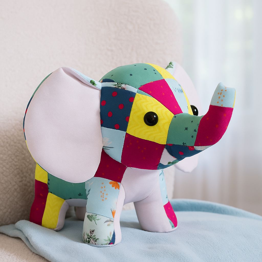 Colorful patchwork elephant plush toy on a soft surface