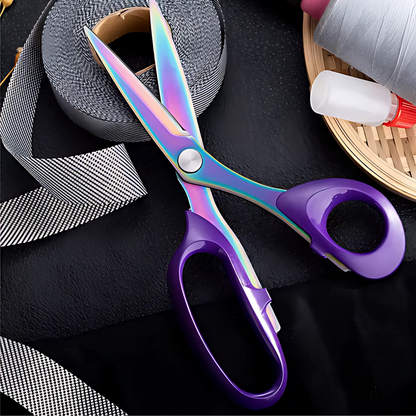 The Professional Fabric Scissors 8" with rainbow-colored blades and purple handles rest on a black surface with ribbon, tape, and other sewing supplies—ideal for precise cutting in quilting projects.