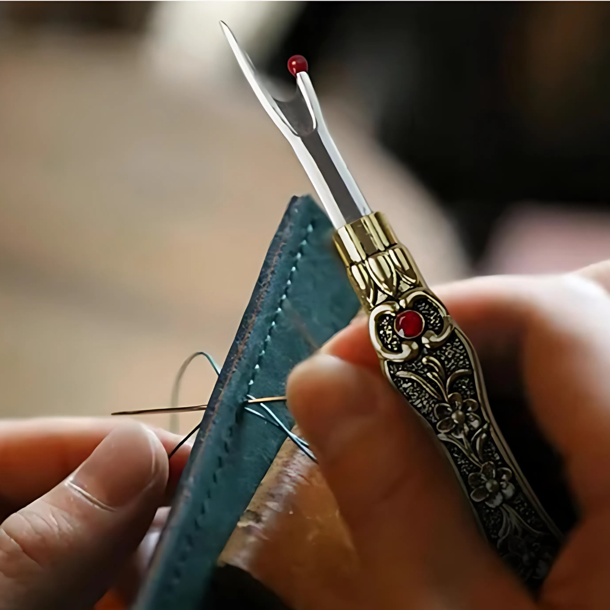 Using a needle and thread to sew leather, a person holds the Vintage Seam Ripper Set, which features an ergonomic design and red stone decoration for added vintage charm.
