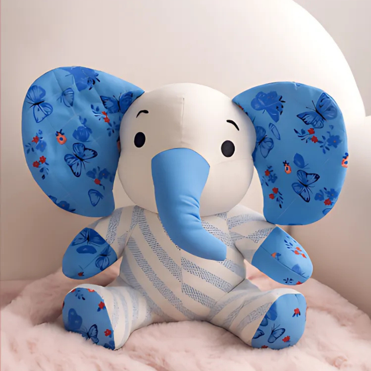 Trudy the Elephant Downloadable PDF Quilt Pattern features a charming elephant with blue patterned ears and trunk, inspired by classic quilting designs, displayed on a soft pink surface against a pale background.