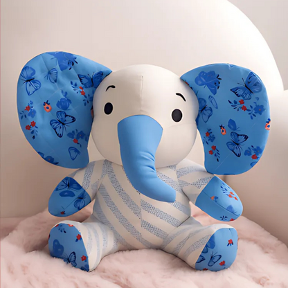 Trudy the Elephant Downloadable PDF Quilt Pattern features a charming elephant with blue patterned ears and trunk, inspired by classic quilting designs, displayed on a soft pink surface against a pale background.