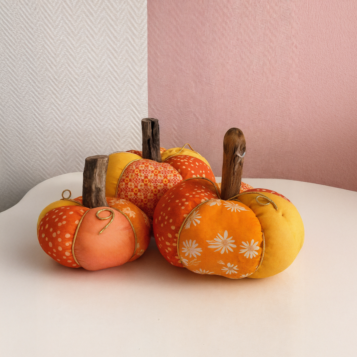 The Little Pumpkins Downloadable PDF Quilt Pattern features four fabric pumpkins with orange and yellow quilting patterns and wooden stems—ideal for cozy fall decor on your table or mantel.