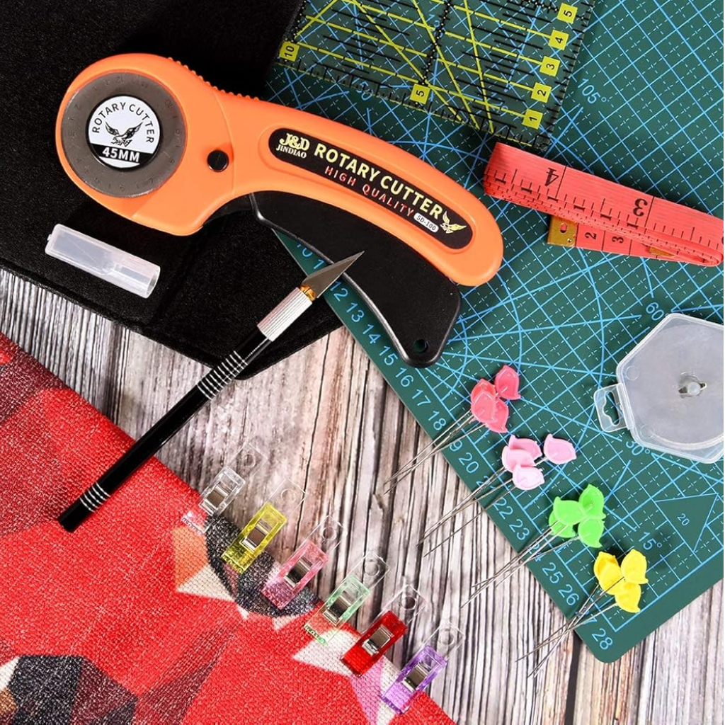 The 97-Piece Quilting Kit: Perfect for Beginners includes a rotary cutter, fabric cutter, colored clips and pins, measuring tape, cutting mats, and a precision tool—an ideal set for any quilting workspace or beginner's setup.