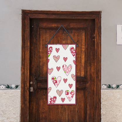 A wooden door displays a customizable Valentine's Day door hanger, created using the "Valentine’s Day Door Hanger Downloadable PDF Quilt Pattern," featuring a sign decorated with red and pink heart appliqués.