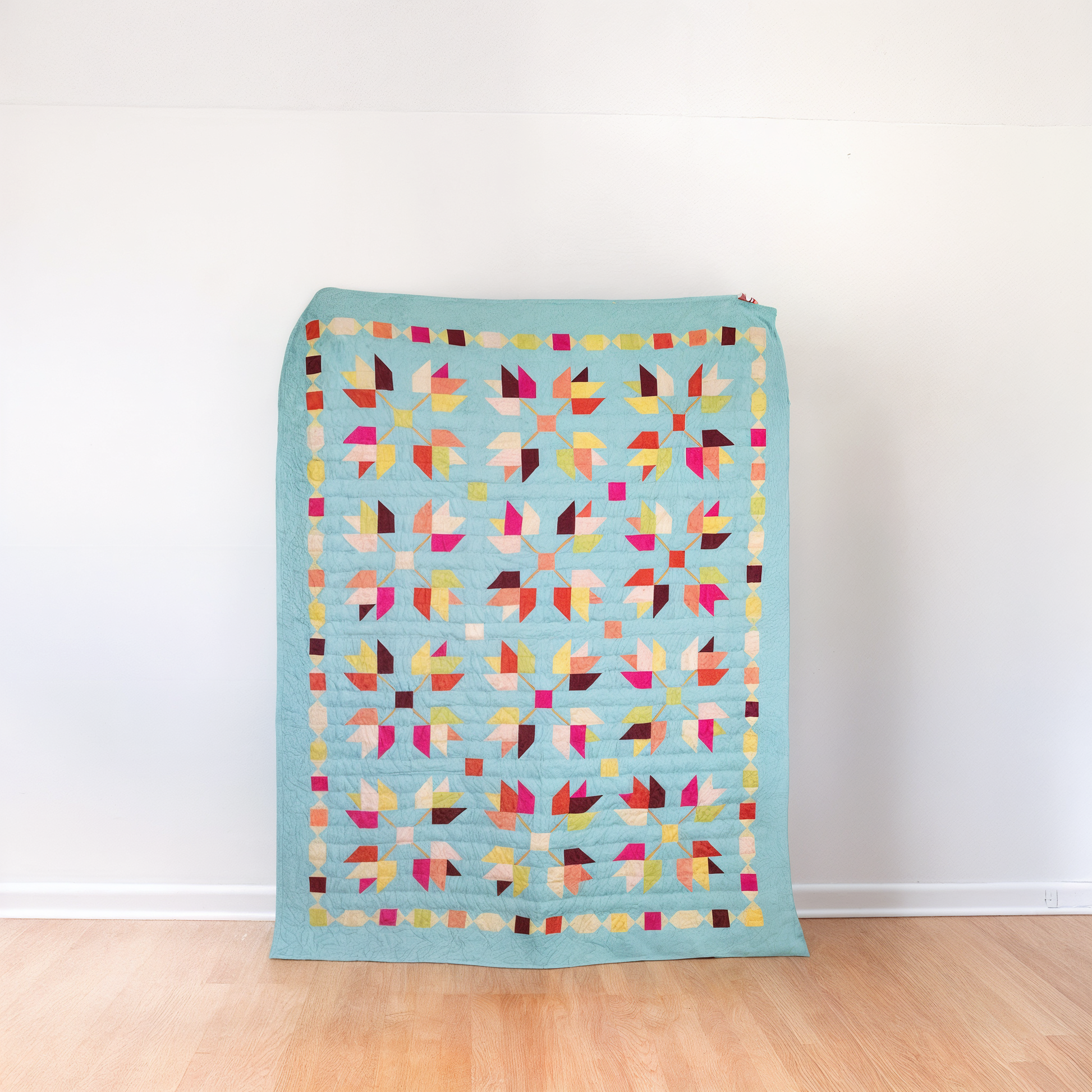 The Falling Autumn Downloadable PDF Quilt Pattern features a geometric leaf design with a blue border—perfect for creating a cozy throw quilt or showcasing your favorite autumn-inspired décor.